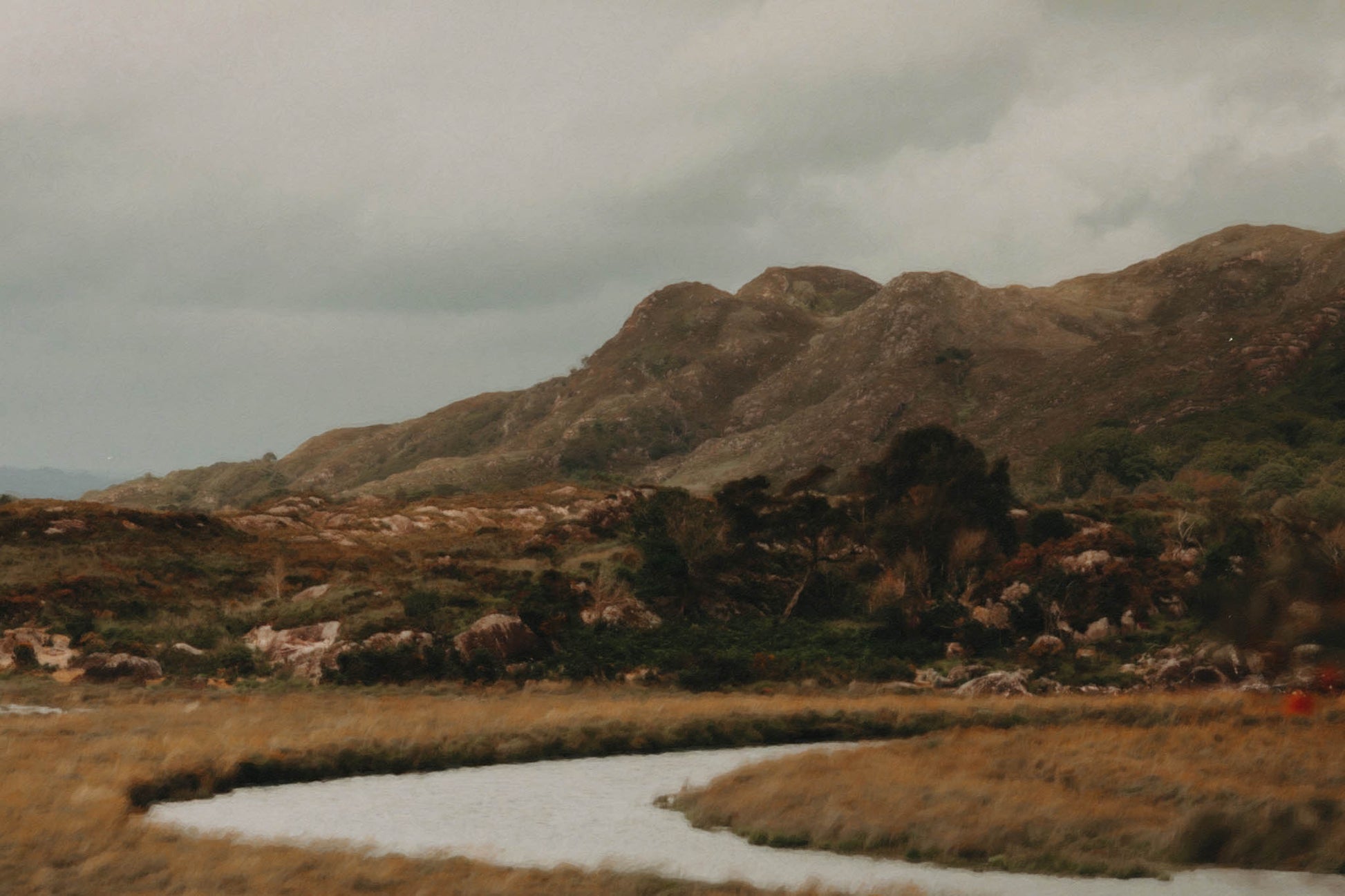 Originally a photograph and now rendered in painterly detail, this print captures the raw elegance of Ireland’s untamed heart. The winding river carves through golden grasses, leading the eye to ancient hills cloaked in heather and stone. A still moment in a shifting land—this piece speaks to those who crave the hush of wild places, the grounding pull of earth tones, and the timeless rhythm of the Irish landscape.